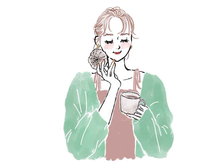 ドーナツ食べてコーヒー持つおしゃれな女性